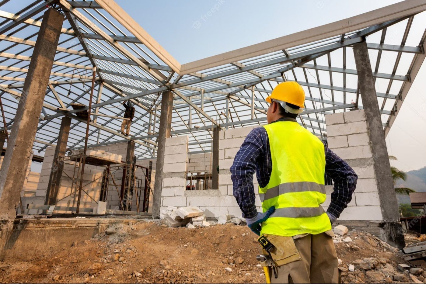 Engineer reviewing a steel roof structure on site